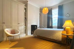 een slaapkamer met een bed, een stoel en een tafel bij Coastal luxury: five minute stroll to the beach. in Queenscliff