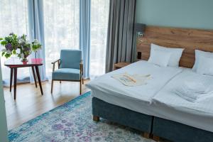 a bedroom with a bed and a table and a chair at Ohana Space w Juracie in Jurata