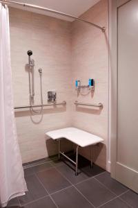 a shower stall with a bench in a bathroom at Aloft Columbus Westerville in Westerville