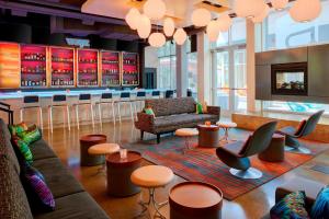 a bar with couches and stools in a room at Aloft Columbus Westerville in Westerville
