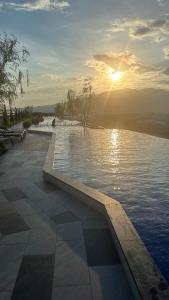 uma piscina de água com o sol ao fundo em Astra Sky River Chiang Mai em Chiang Mai