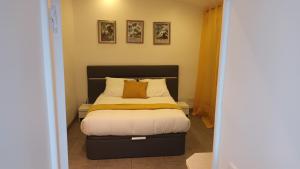 ein Schlafzimmer mit einem Bett mit einer gelben Decke darauf in der Unterkunft Appart paisible in Athis-Mons