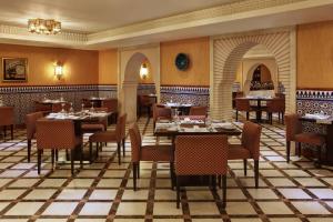 أبراج لو ميريديان مكة في مكة المكرمة: مطعم فيه طاولات وكراسي في الغرفة