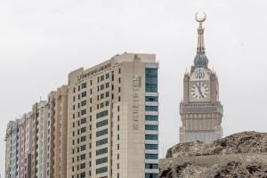 ein hohes Gebäude mit Uhrturm und großem Ben in der Unterkunft Le Meridien Towers Makkah in Mekka