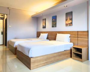 Postel nebo postele na pokoji v ubytování AIRBEST Gemtree Lampang Hotel