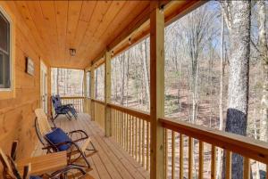 a screened in porch with rocking chairs and windows at New Serene, Fun & Comfy Cabin- Covered Deck, Grill, Arcade in Murphy