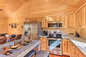 a kitchen with wooden cabinets and a stove top oven at New Serene, Fun & Comfy Cabin- Covered Deck, Grill, Arcade in Murphy