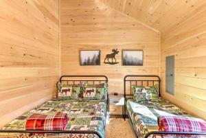 two beds in a room with wooden walls at New Serene, Fun & Comfy Cabin- Covered Deck, Grill, Arcade in Murphy