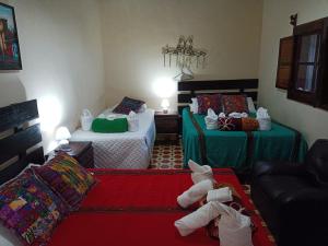 a living room with two beds and a couch at HOSTAL LA PAZ in Antigua Guatemala