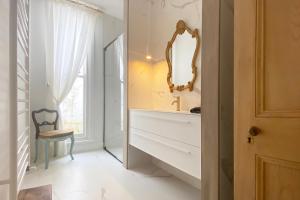 een badkamer met een spiegel, een wastafel en een stoel bij Coastal luxury: five minute stroll to the beach. in Queenscliff