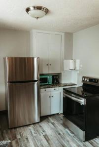 a kitchen with a stainless steel refrigerator and white cabinets at Bluebird Cottage, walking distance to fairgrounds in Hutchinson