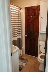 a bathroom with a toilet and a sink and a door at Bluebird Cottage, walking distance to fairgrounds in Hutchinson