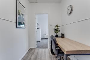 una sala da pranzo con un tavolo e un orologio a parete di Bright and airy cosy cottage, close to town a Thirlmere