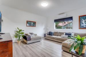 a living room with two couches and a tv at Bright and airy cosy cottage, close to town in Thirlmere