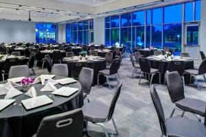 a large banquet hall with tables and chairs and windows at Aloft Wichita in Wichita