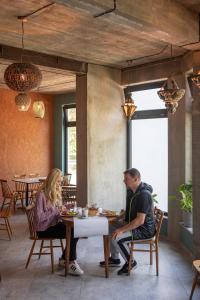 Ohana Space w Juracie في يوراتا: يجلس رجل وامرأة على طاولة في مطعم