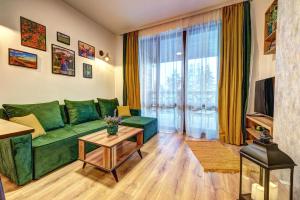 a living room with a green couch and a table at Deer Lake 521 at Oak Residence Hotel & Relax in Smolyan