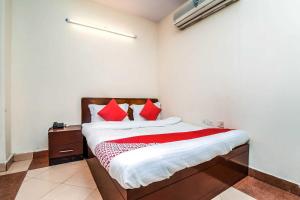 a bedroom with a bed with red pillows at Hotel Kathir Palace in Madurai