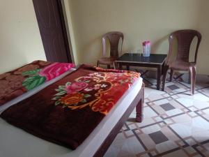 a bedroom with a bed and a table and chairs at Raj palace in Uttarkāshi