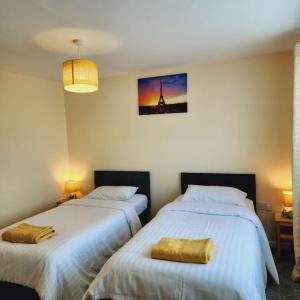 a bedroom with two beds and a picture on the wall at Sunny South Shields House in Jarrow