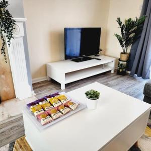 a living room with a tv and a table with food at Sunny South Shields House in Jarrow
