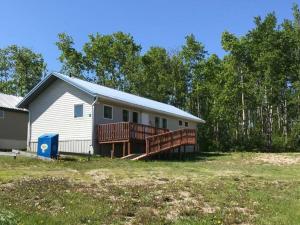 a house with a large deck in a yard at HI Rossburn 9 Finger Ranch in Rossburn