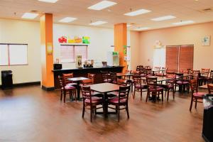 a dining room with tables and chairs and a bar at Trident Inn & Suites New Orleans in New Orleans