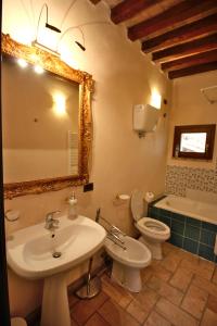 y baño con lavabo, aseo y espejo. en Le Logge Di Silvignano, en Campello sul Clitunno