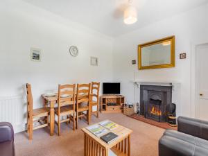 a living room with a table and a fireplace at Lockview Upper Flat in Fort Augustus