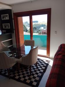 sala de estar con mesa, sillas y ventana en Estadia Barragem do Salto - Casa Mugam, en São Francisco de Paula