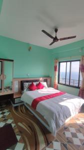 a bedroom with a large bed and a ceiling fan at Sarangkot Hotel New Galaxy in Pokhara