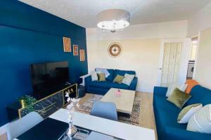 a blue living room with a blue accent wall at Family Marine Apartment with Sea View in Dawlish