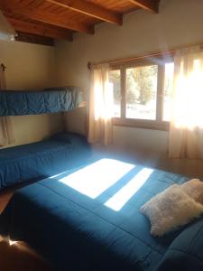 a bedroom with two beds and a window at Posada del Ñireco in San Carlos de Bariloche