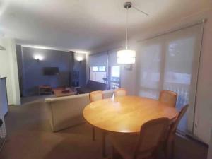 a dining room with a table and a couch at Departamento Termas de Chillán in Pinto