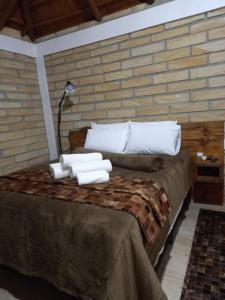 1 dormitorio con 1 cama con toallas en KARAPOTÓ parador rural, en Cambará