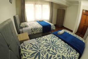 une chambre avec deux lits et un canapé et une fenêtre dans l'établissement Centric & cozy apartment with Garage, à Cusco