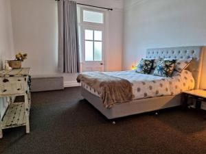 a bedroom with a large bed and a window at The Bank On Kelly Hygge Villa, Scone in Scone