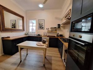 a kitchen with a table in the middle of it at The Bank On Kelly Hygge Villa, Scone in Scone