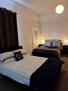 a bedroom with two beds and a window at The Bank On Kelly Hygge Villa, Scone in Scone