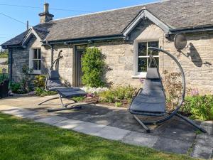 a couple of chairs in front of a house at Riverside Cottage in Blair Atholl
