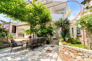 eine Terrasse mit Tisch und Stühlen vor einem Gebäude in der Unterkunft Apartments Emmeline in Tisno
