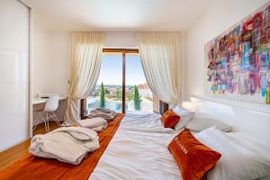 a bedroom with two beds and a large window at Villa Nena in Kakma