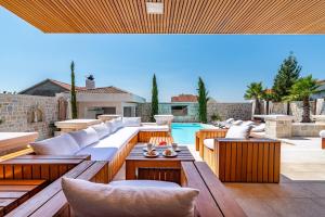 a patio with wooden furniture and a swimming pool at Villa Nena in Kakma