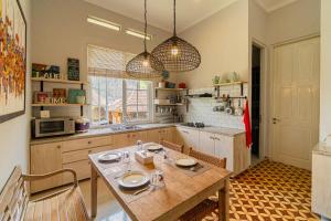 a kitchen with a wooden table with plates on it at Four Monkeys House in Bedugul