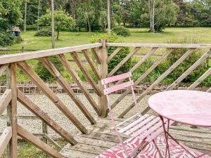 Hollesley的住宿－夜鶯鄉村別墅，木甲板上的粉红色桌子和粉红色椅子