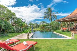 un complejo con una piscina y un patio con sillas en Bali Sawah Indah, en Ubud