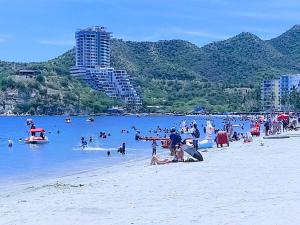 a beach with a bunch of people in the water at Hugos studio loft in Gaira