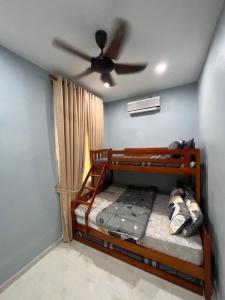 a bedroom with two bunk beds and a ceiling fan at Arryantz by the beach in Bachok