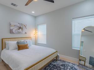 a bedroom with a bed with white walls and a window at Luxury cottage in San Antonio