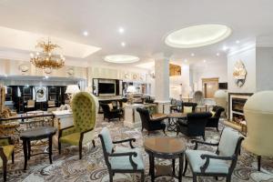 duży salon z krzesłami i stołami w obiekcie Protea Hotel by Marriott Johannesburg Balalaika Sandton w mieście Johannesburg